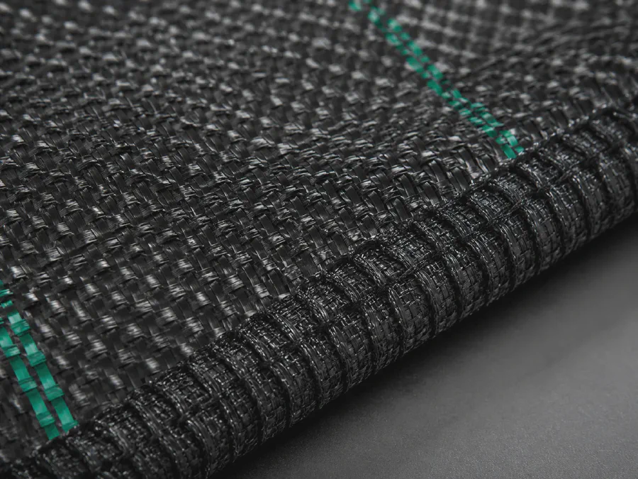 Close-up texture of PP woven weed mat showing fabric density and edge strength