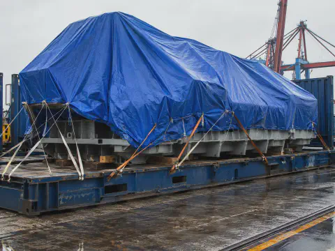 Blue tarpaulin cover for large machine export transport protection