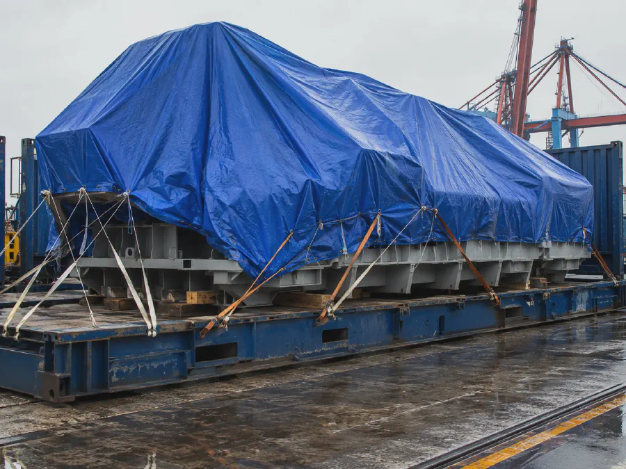 Blue tarpaulin cover for large machine export transport protection