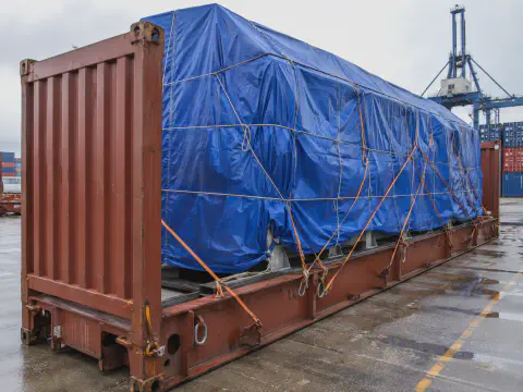 Blue tarpaulin cover for oversized cargo loaded in an open top container