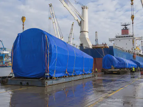 Blue tarpaulin covers for wind power equipment waiting for port loading