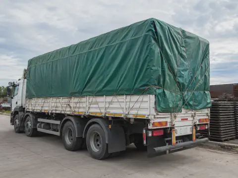 Green tarpaulin truck cover application for outdoor cargo protection