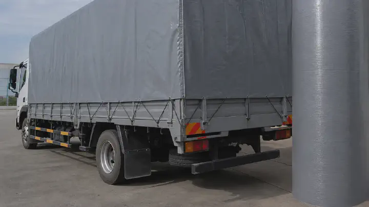 Truck cover beside a laminated woven tarpaulin fabric roll