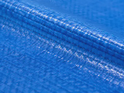 Close-up laminated surface detail of blue PP PE woven tarpaulin roll